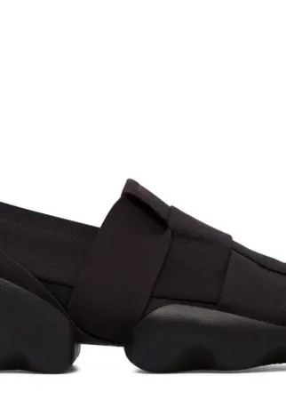 Born from a fusion of futuristic urban styles and inspirations from nature, these black lightweight sneakers showcase sophistication and technology. Black elastic straps cross over lightweight polyester to give you all the flexibility you need. The sneakers have iconic soles inspired by tree leaves, and removable insoles to cushion your feet.